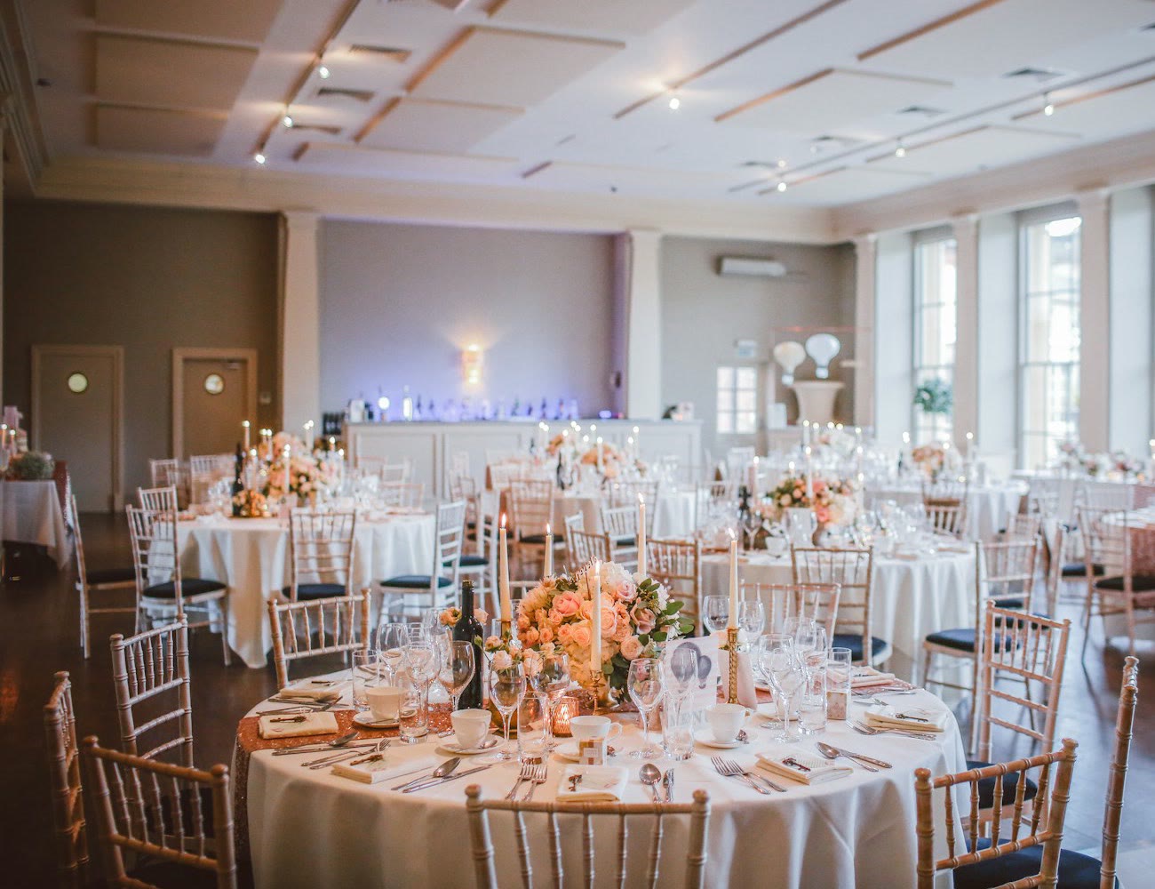 Salón con mesas redondas montadas y centros de flores